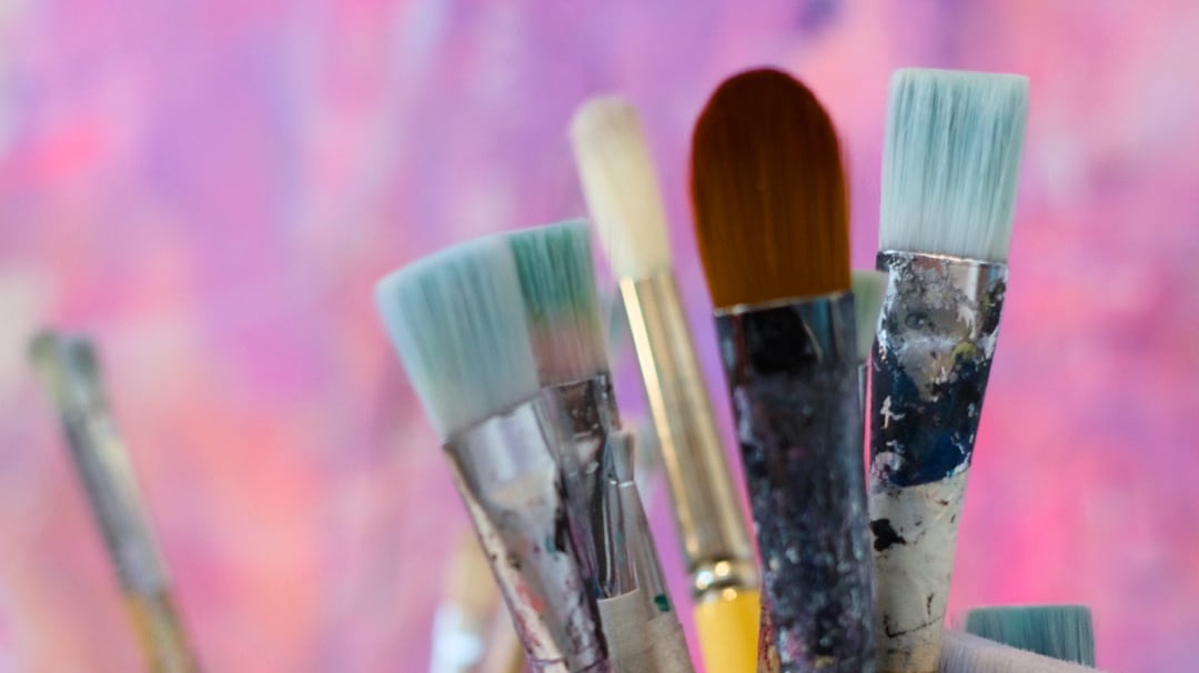 Criss Chaney Art Classes pink background with paintbrushes