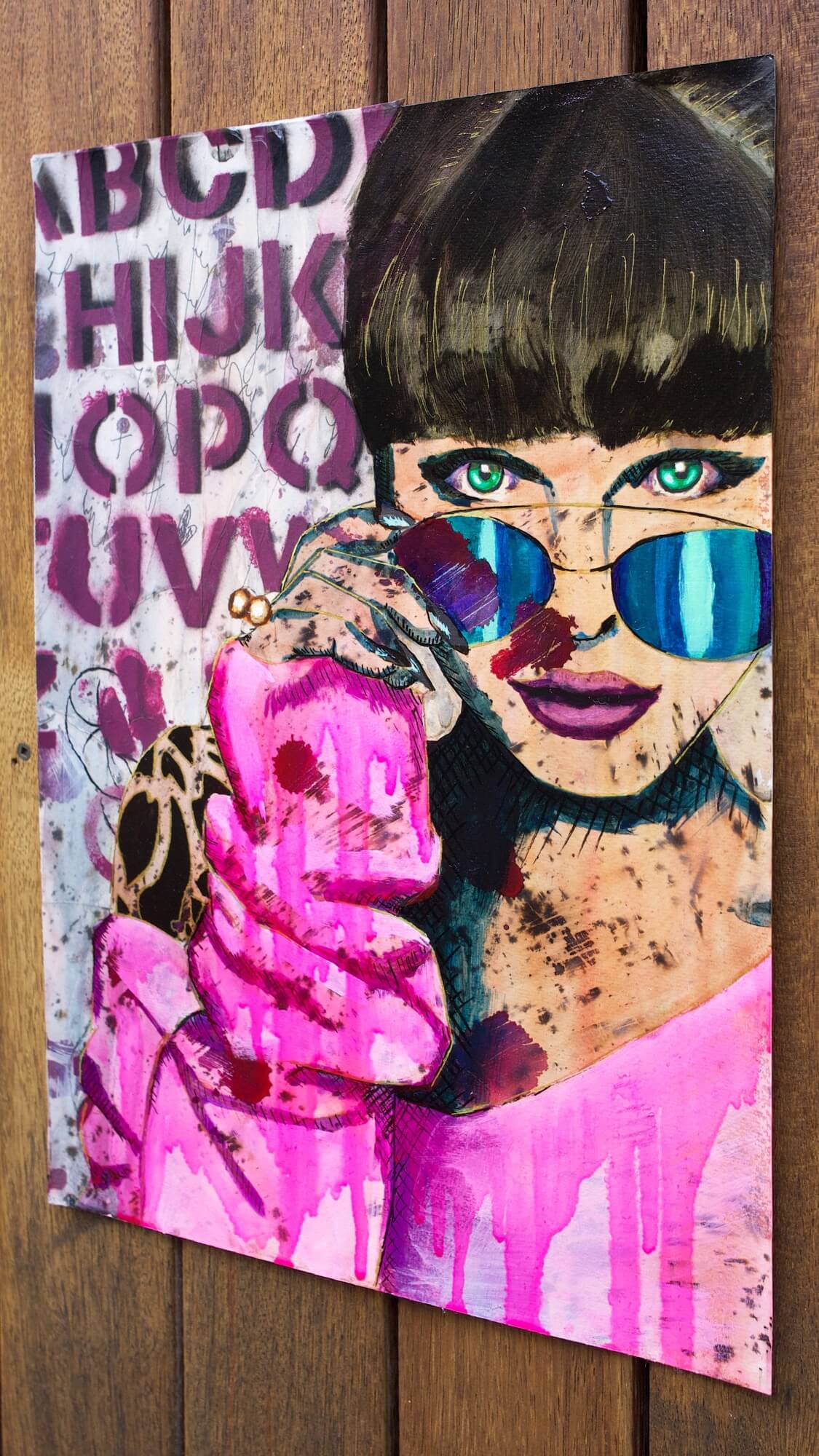 Painting of a woman wearing hot pink sweater and colourful sunglasses